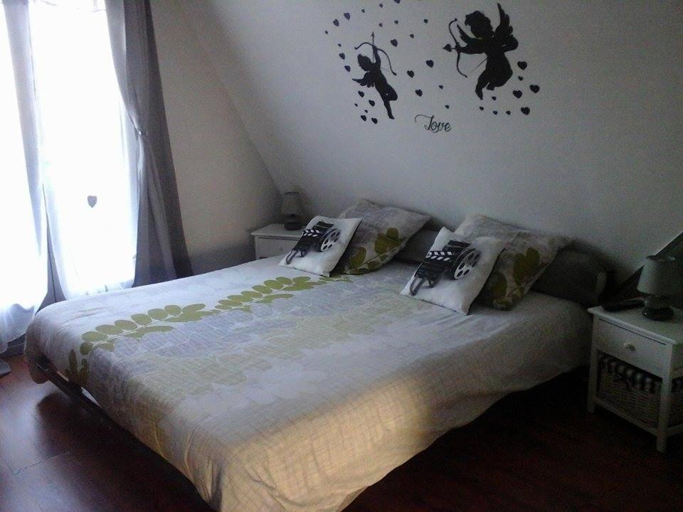 um quarto com uma cama com uma aranha na parede em Chez Marcelline em Amécourt