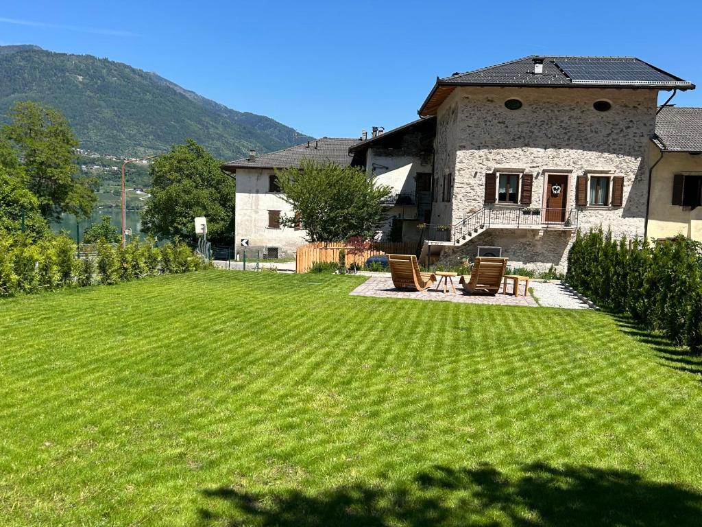 a yard with two chairs and a house at Palazzo Tamanini in Calceranica al Lago
