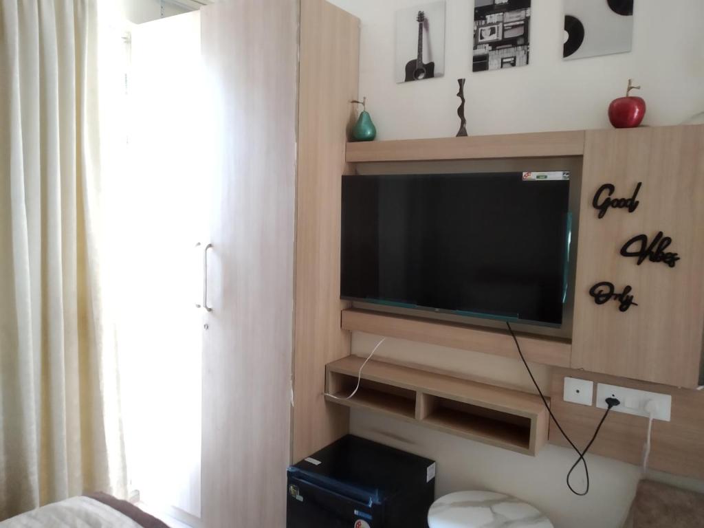 a living room with a flat screen tv on a wall at The kanha Luxury Suites in Greater Noida