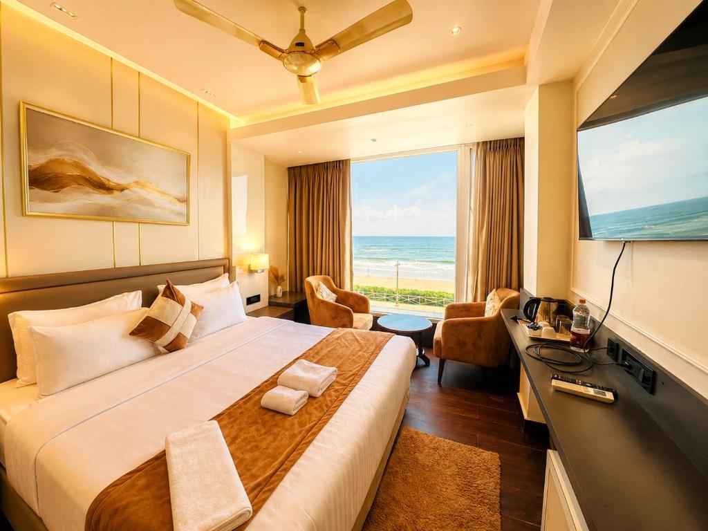 a hotel room with a large bed and a large window at Hotel Eastern Dham Puri in Puri