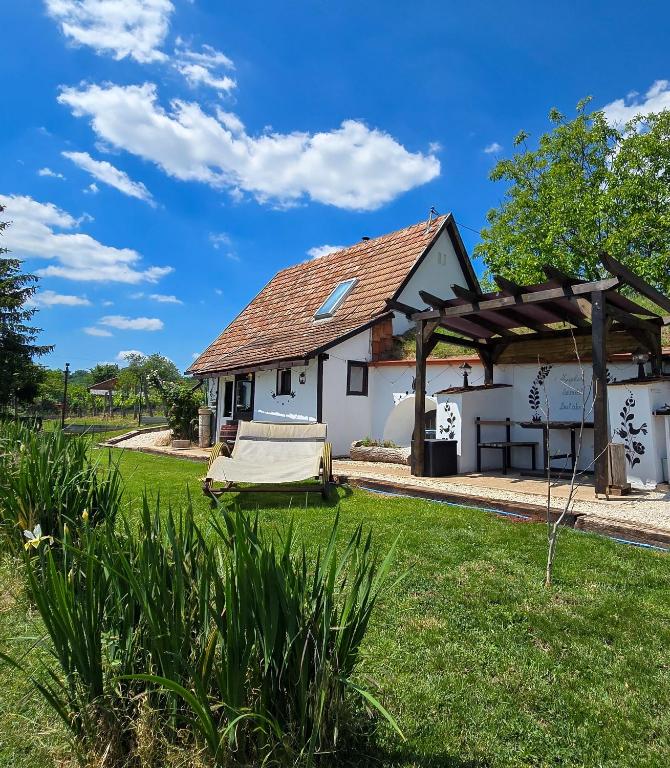 a white house with awning in a yard at Házikó Balatonalmádi in Balatonalmádi