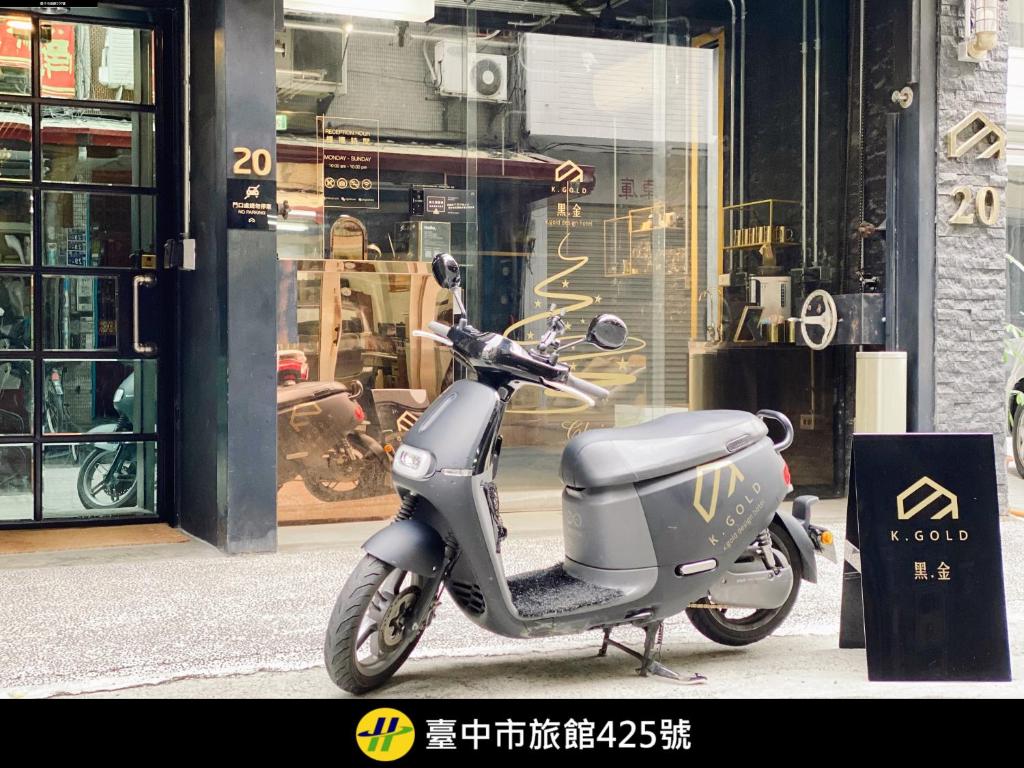 a scooter parked on a sidewalk in front of a store at K. Gold in Taichung