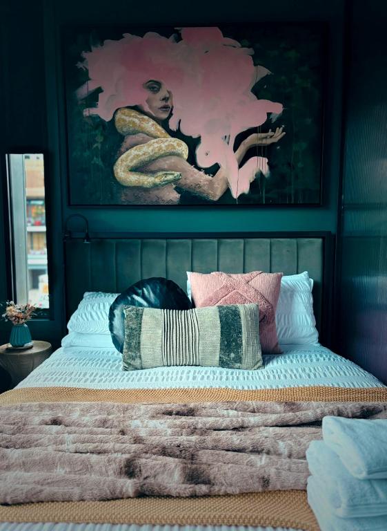 a bedroom with a bed with a painting on the wall at Green Rooms Braddon - Designer Micro Apartments in Braddon