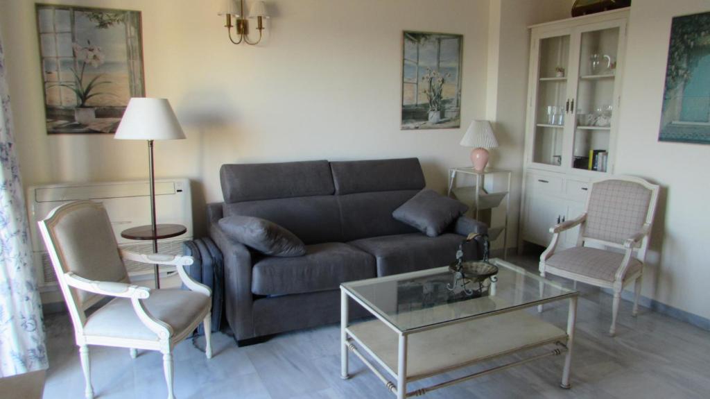 a living room with a couch and a table and chairs at Home4Holidays in Nerja