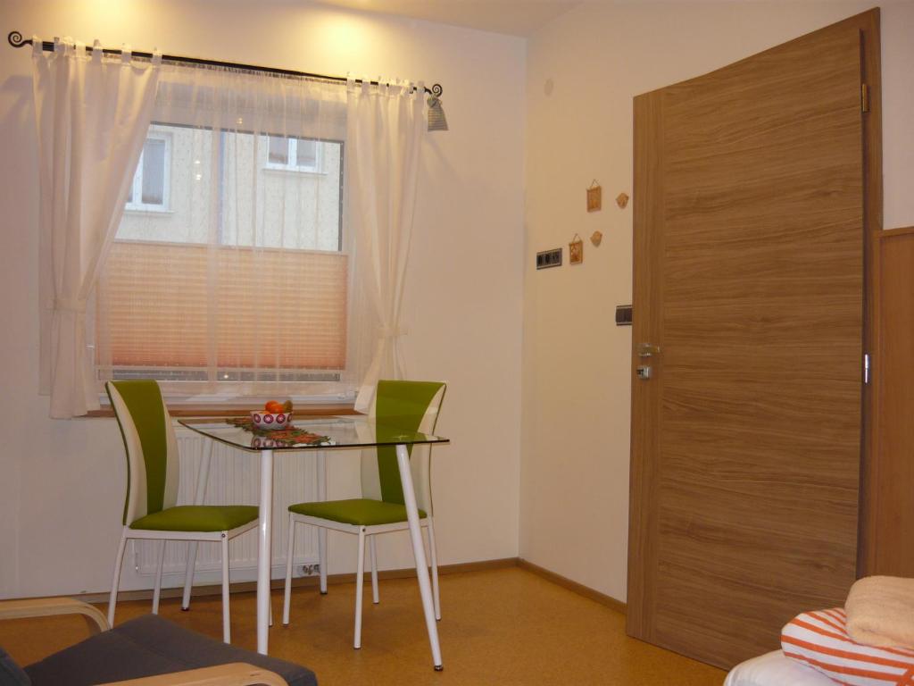 Pokój ze stołem, krzesłami i oknem w obiekcie Apartments - Penzion Lena w mieście Hradec Králové
