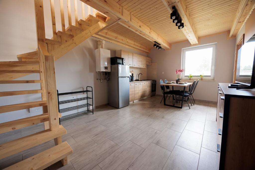 a kitchen with a staircase and a table in a room at Agroturystyka Oliweczka 24 in Potok Wielki