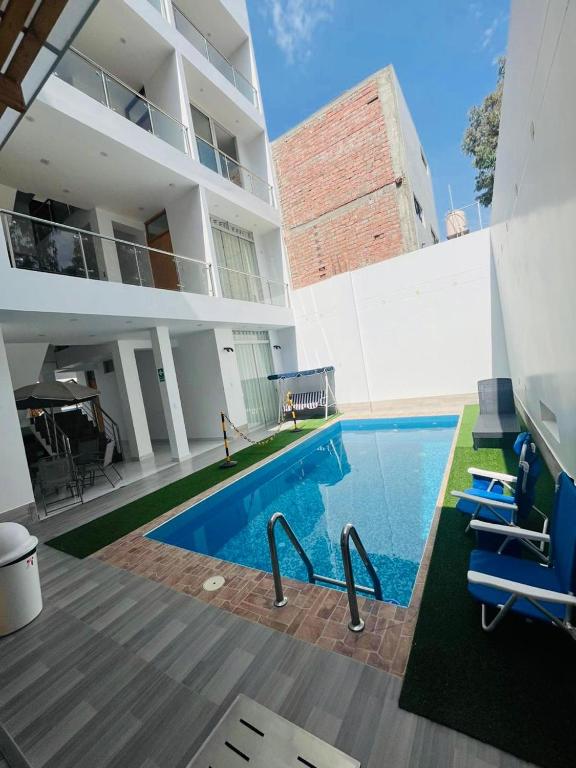 a swimming pool in front of a building at Hurin Perú in Ica