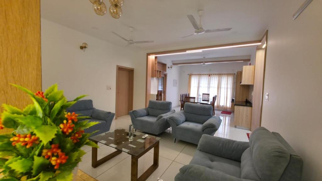 a living room with couches and a table at Science House Lux Inn in Kadayirippu
