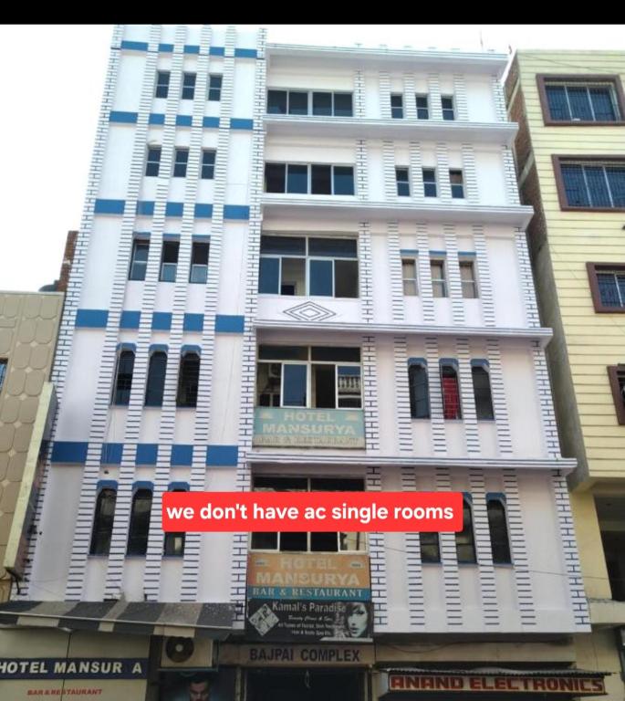 a tall white building with a sign that says we dont have are single rooms at Hotel mansurya in Jamshedpur