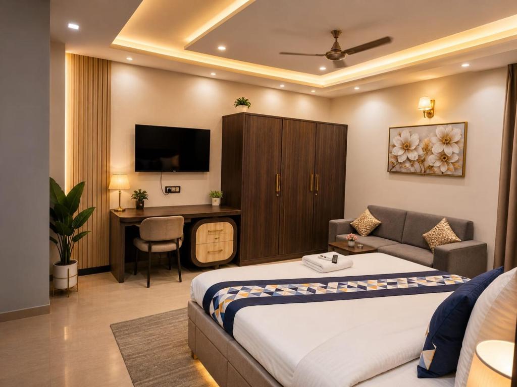 a bedroom with a bed and a couch and a desk at Hotel Aarav 94 in Indore