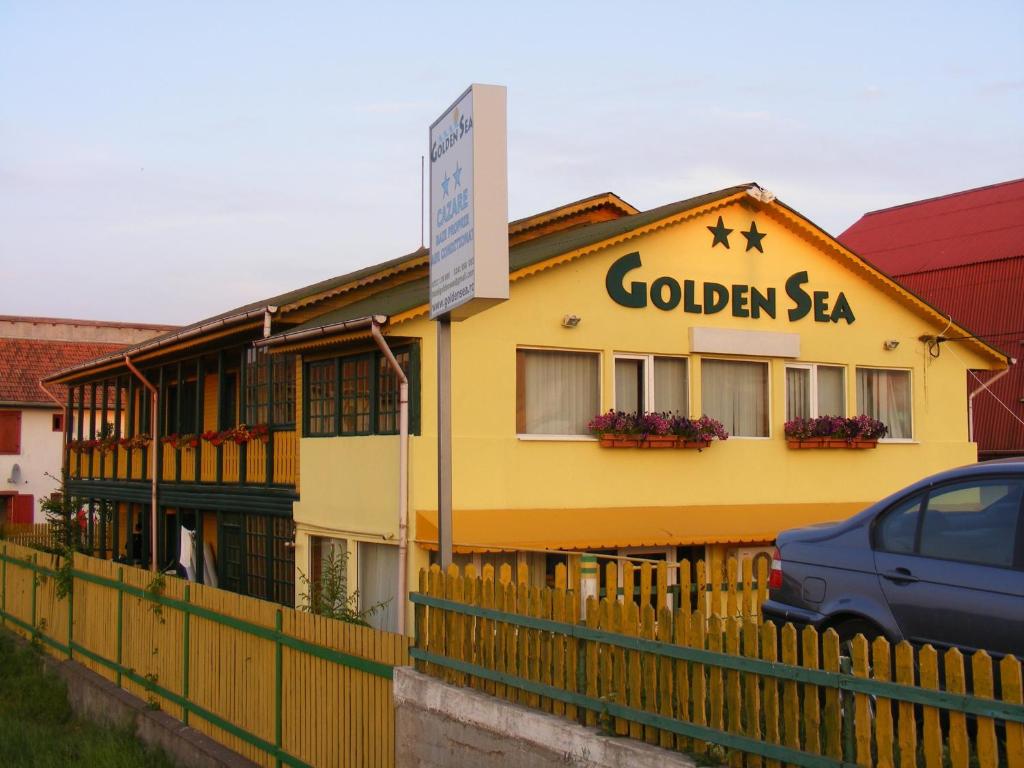 ヴァマ・ヴェケにあるHotel Golden Seaの黄金の海を読む看板のある黄色い建物