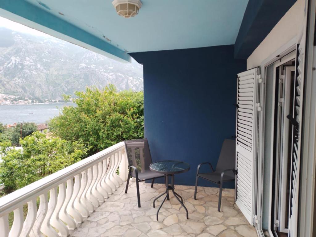 a balcony with two chairs and a blue wall at Muo Suntime apartment in Muo