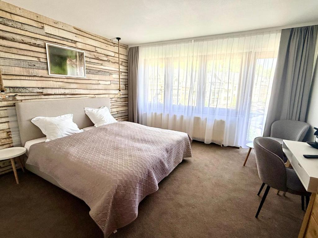 a bedroom with a bed and a table and chairs at Hôtel Albert 1er in Malmedy