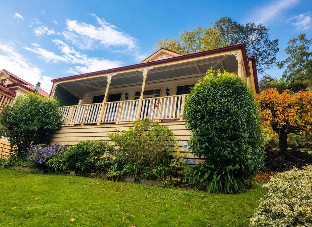 a house with a white fence and a yard at Charnwood Cottages in Warburton