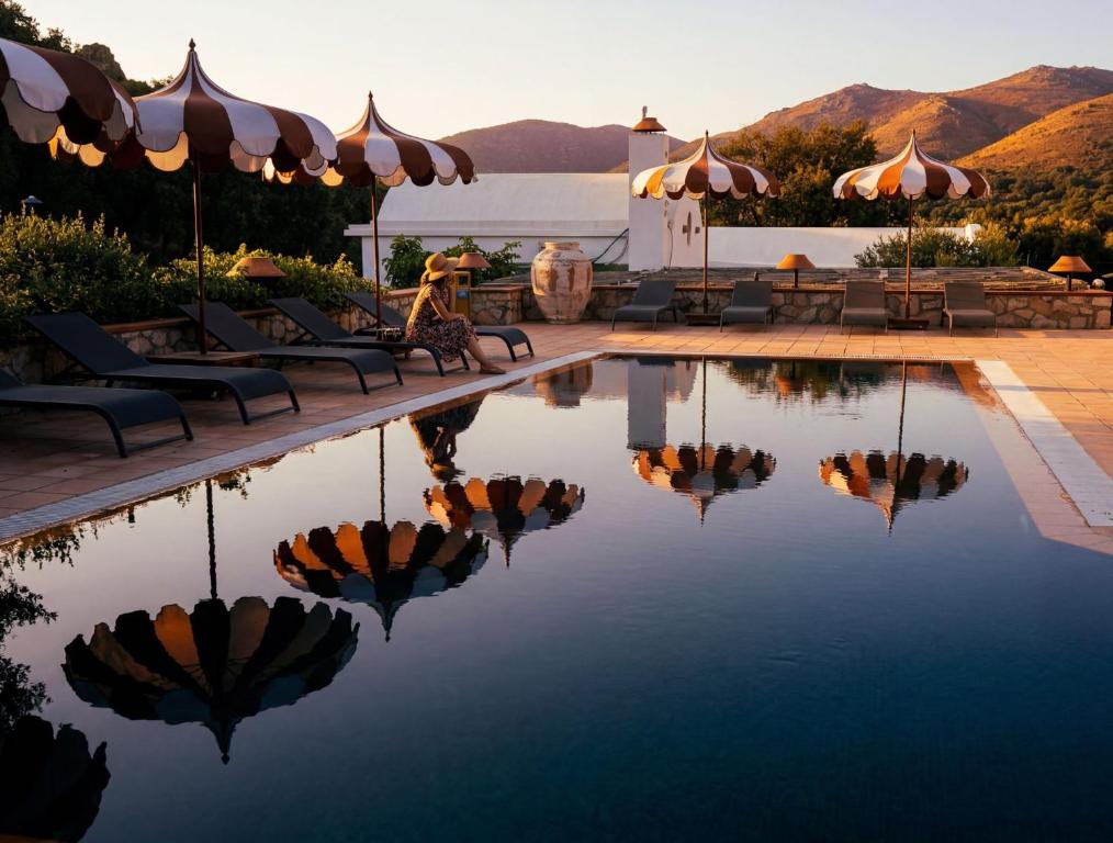 a pool with chairs and umbrellas on a resort at Odette Pansiyon Bodrum in Bodrum City