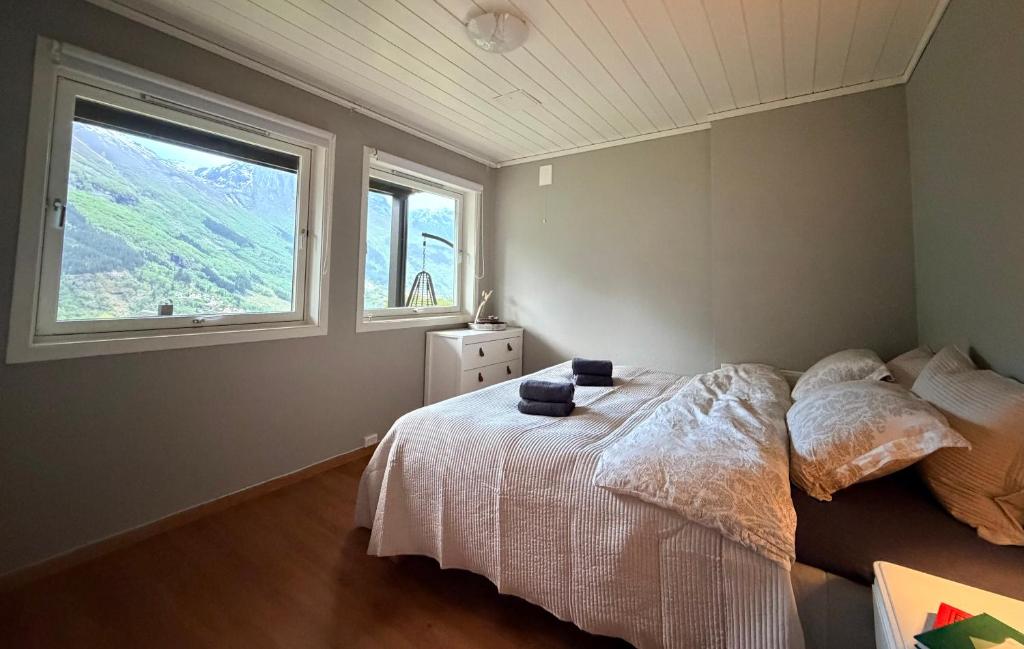 a bedroom with a bed and two windows at StarapApartment Odda 3 BR in Odda