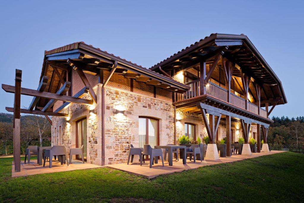 a house with tables and chairs in front of it at Saiaritz in Amurrio