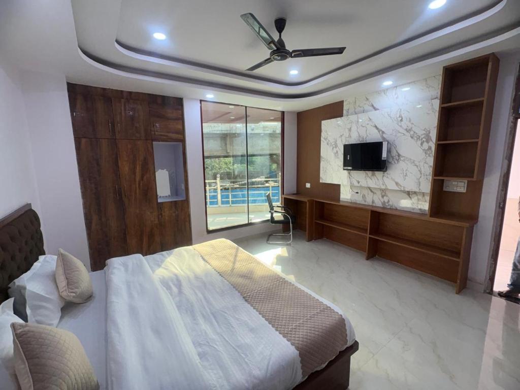 a bedroom with a bed and a flat screen tv at Sai Sansthan Inn in Lucknow