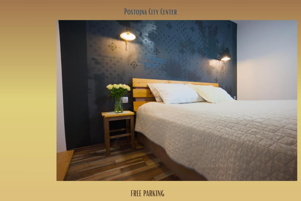 a bedroom with a bed and a vase of flowers on a table at FRIZ&FANY Charm House in Postojna