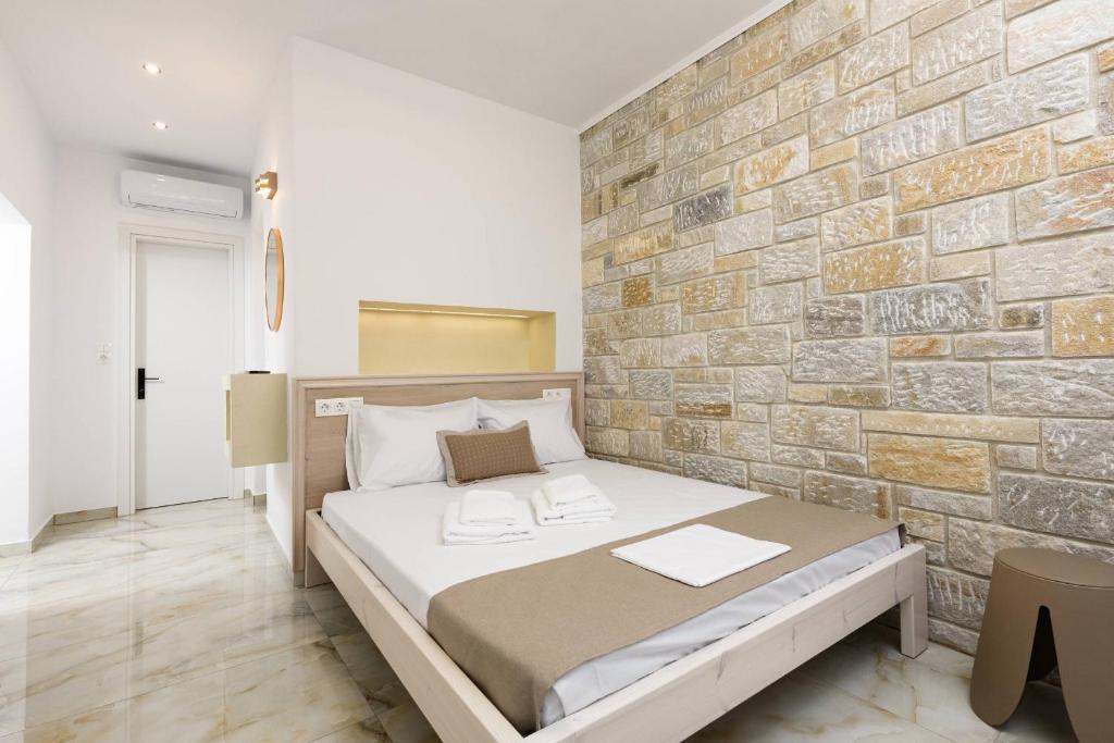 a bedroom with a brick wall and a bed at VillAge 1912 Studios in Panagia