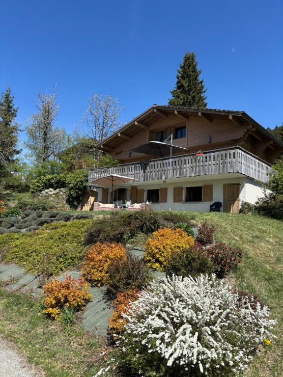 a house on a hill with flowers in front of it at Charmant appartement avec jardin et magnifique vue in Saint-Jean-de-Sixt
