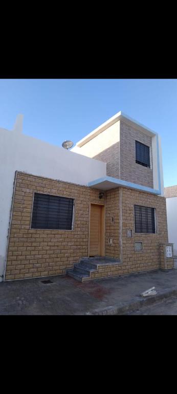 a brick building with a brown door and stairs at Mini villa al hoceima in Al Hoceïma