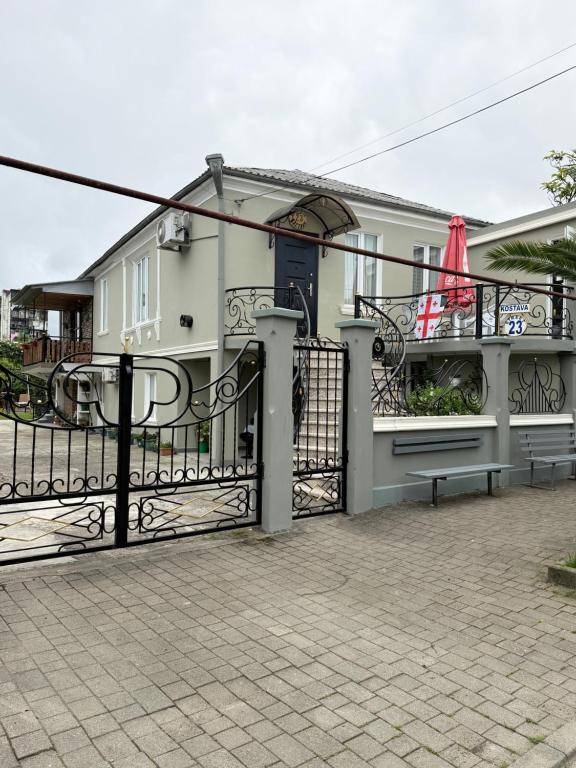a white house with a black gate in front of it at Guest House on Kostava 23 in Kobuleti