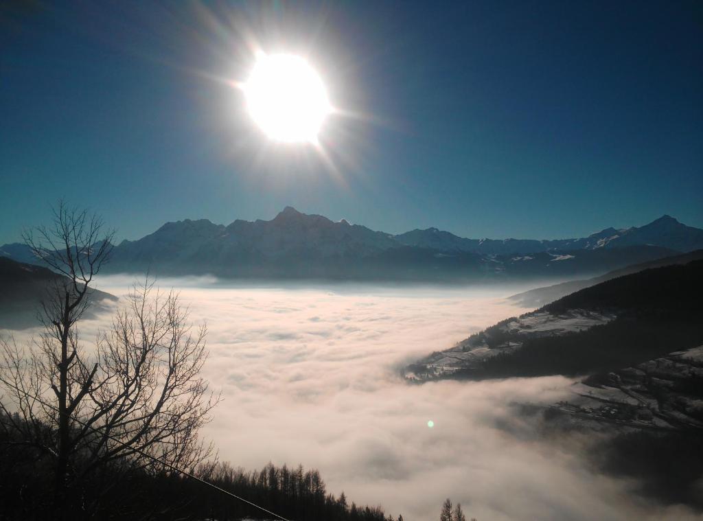 einen Blick auf die Sonne, die über einem Meer von Wolken aufgeht in der Unterkunft B&B EnChanté in Allein