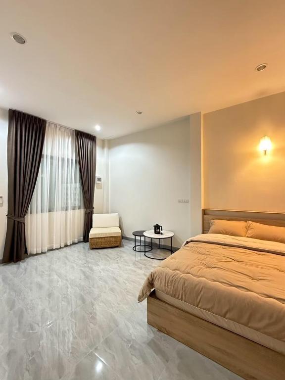 a bedroom with a large bed and a chair at KlomKlom garden home in Ban Tha Kham