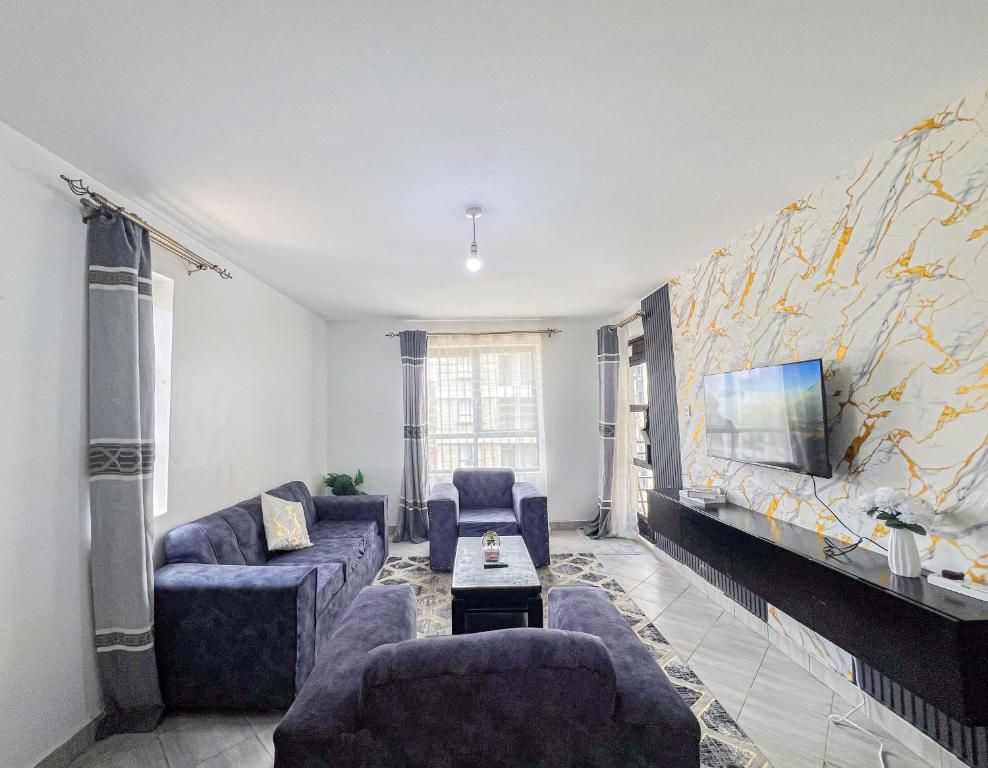 a living room with two couches and a tv at The Escape Muthiga Waiyaki way in Nairobi