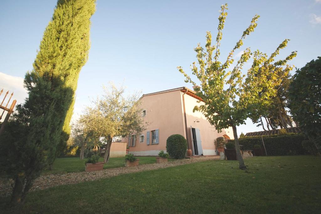 a house in a yard with trees in front of it at Villa Anna in Colle Val D'Elsa