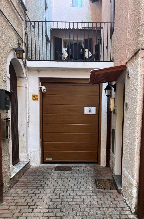 a wooden garage door in a building with a balcony at Cà Rosina Casavacanze in Brusimpiano