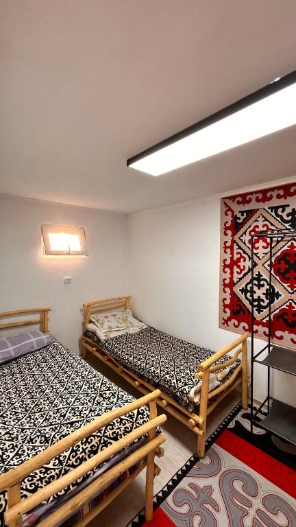 two beds in a room with a painting on the wall at Crocodile Tash in Tong
