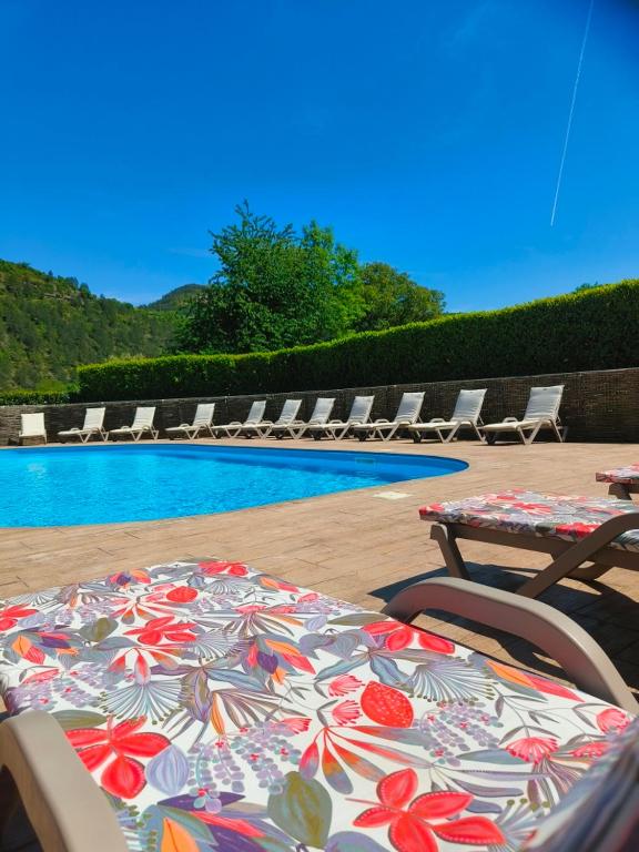 a table and chairs next to a swimming pool at Chalets de la Colagne in Chirac