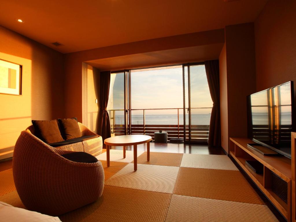 a living room with a television and a couch and a table at ゆうみ in Kyonan