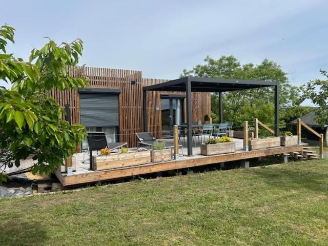 a wooden deck with a gazebo in a yard at Gîte de la Vigne in Ley