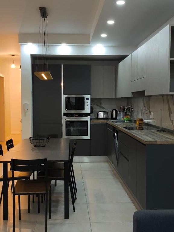 a kitchen with a table with chairs and a microwave at Link Point -Private room in shared Apartment in Misraħ Il-Barrieri