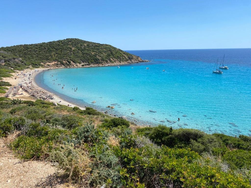 a beach with a group of people in the water at Relax tra mare e monti Flumini di Quartu in Santa Luria