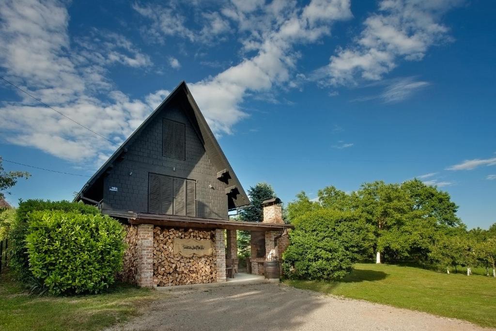 a building with a black roof on a field at Podroom LauMarYvo in Dugo Selo