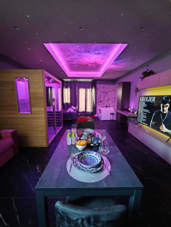 a dining room with a table with purple lighting at Suite Romantica con Jacuzzi e Sauna in Porto Empedocle