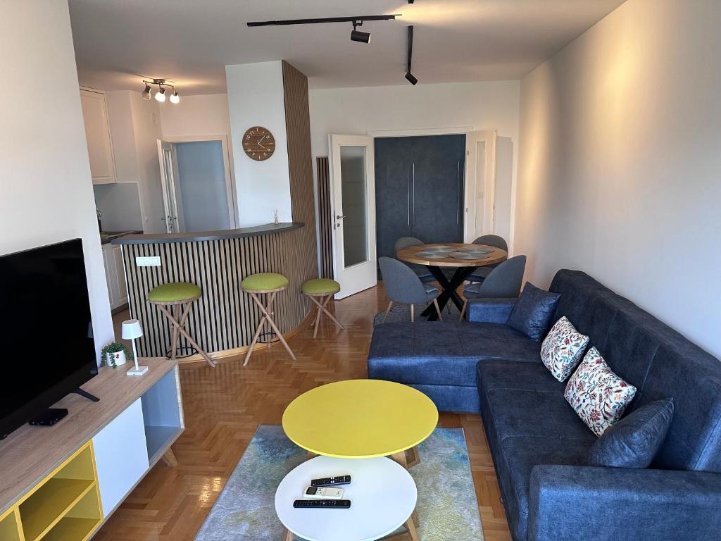 a living room with a blue couch and a table at Residence 16 in Belgrade