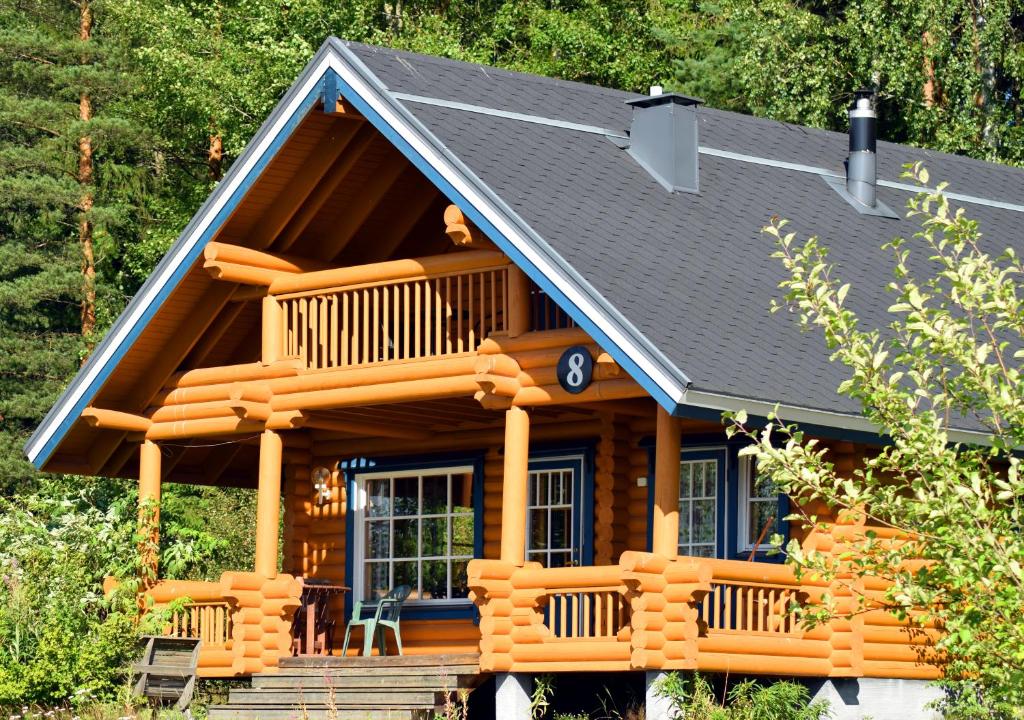 Cabaña de madera con porche y terraza en Hotel Hanhi Cottages, en Lapinjärvi