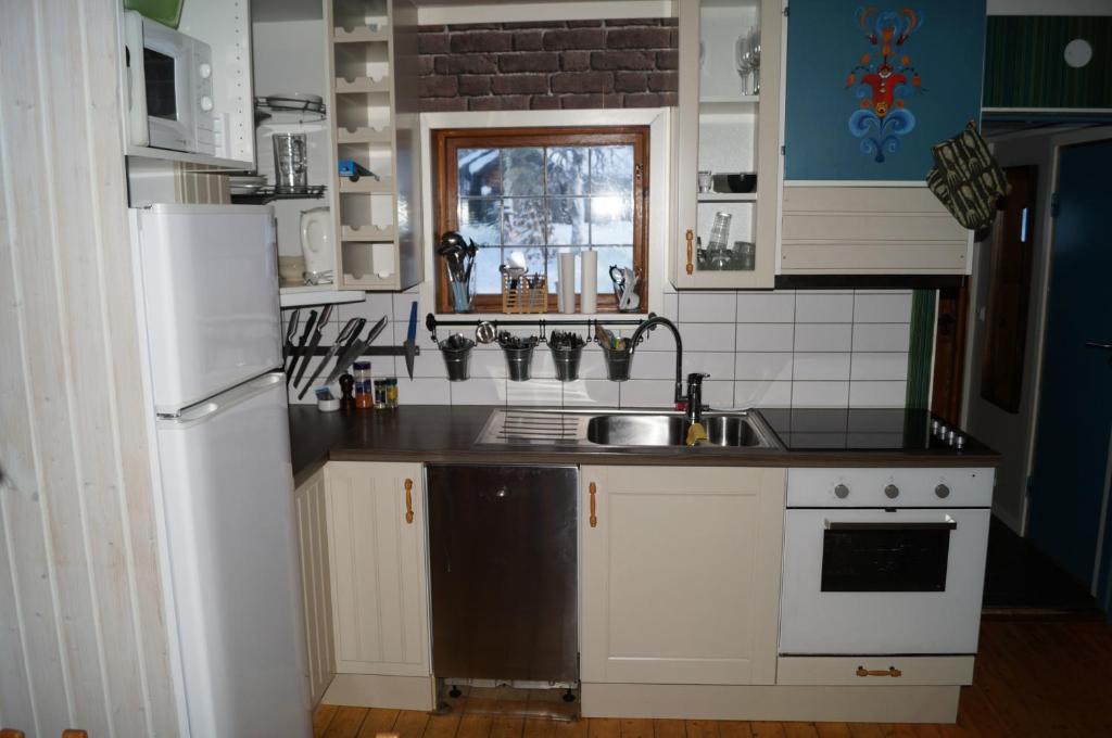 a kitchen with a sink and a white refrigerator at Värmlandsstugan in Sälen