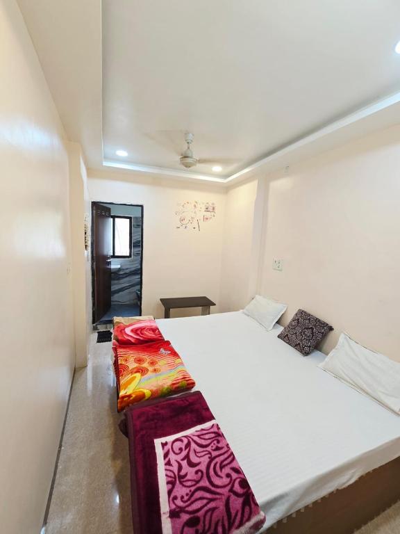 a bedroom with a large white bed in a room at Shri Vinayak Guest House Omkareshwar in Godarpura