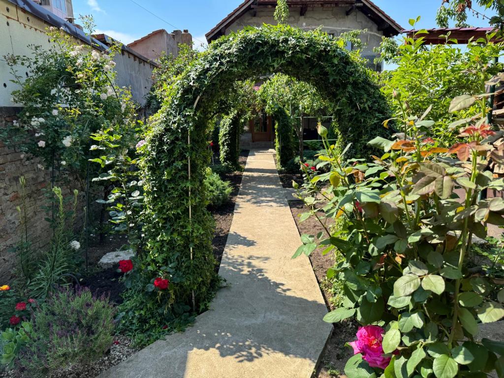 an archway in a garden with flowers and plants at Villa Garden in Drobeta-Turnu Severin