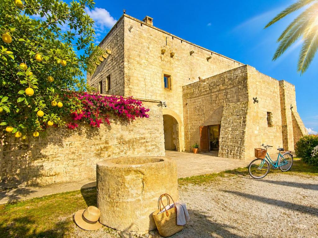 an old stone building with a bike parked in front of it at Masseria La Millenaria in San Foca