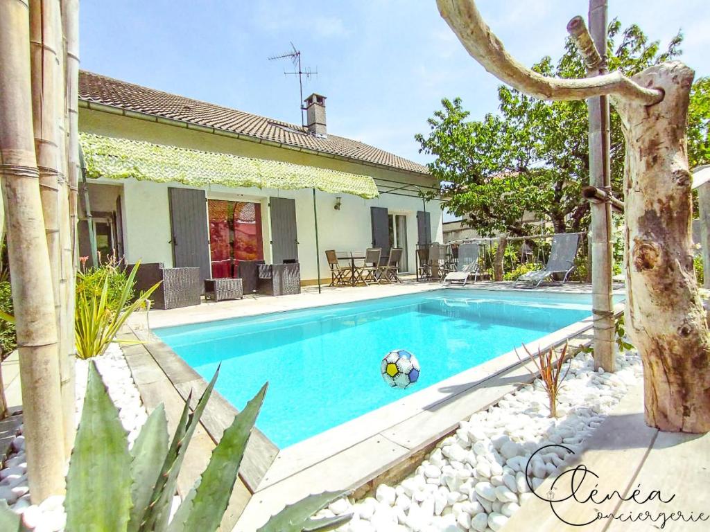 a swimming pool with a ball in front of a house at L'Escapade Albigeoise in Albi