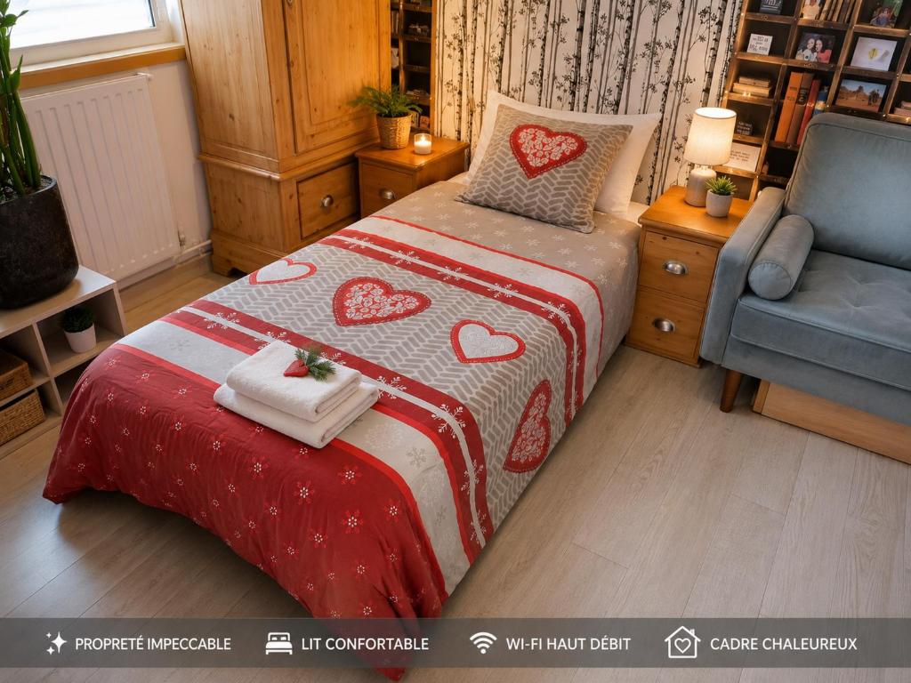 a bedroom with a bed with a red and white blanket at Un coin de paradis in Oullins