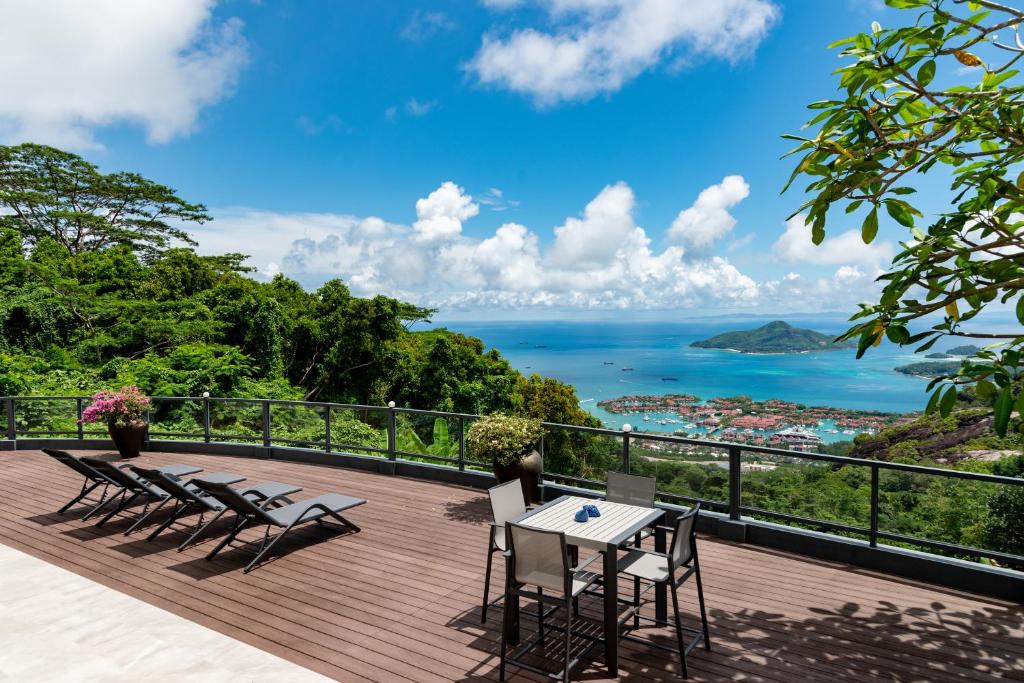 a deck with chairs and a table with a view of the ocean at Fairview Heights in Victoria