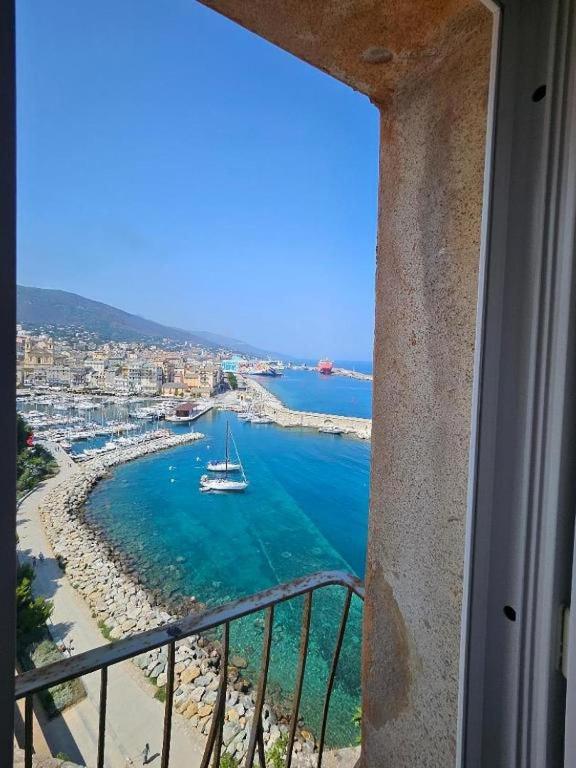 a view of a harbor with a boat in the water at superbe appartement de prestige avec vue mer in Bastia
